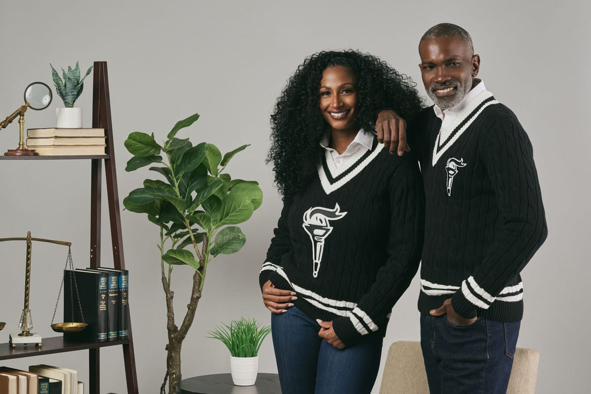 Man and woman wearing black National Bar Association cricket sweaters