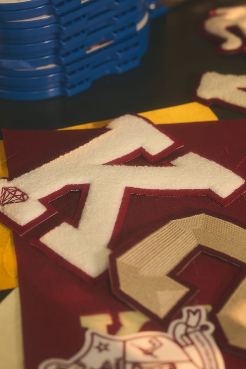 Close-up of chenille Kappa Alpha Psi letters on a maroon jacket
