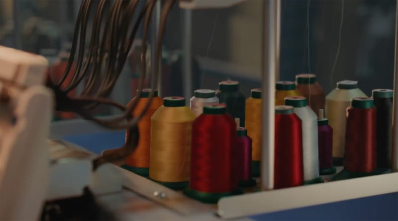 Colorful spools of embroidery thread loaded on an industrial embroidery machine