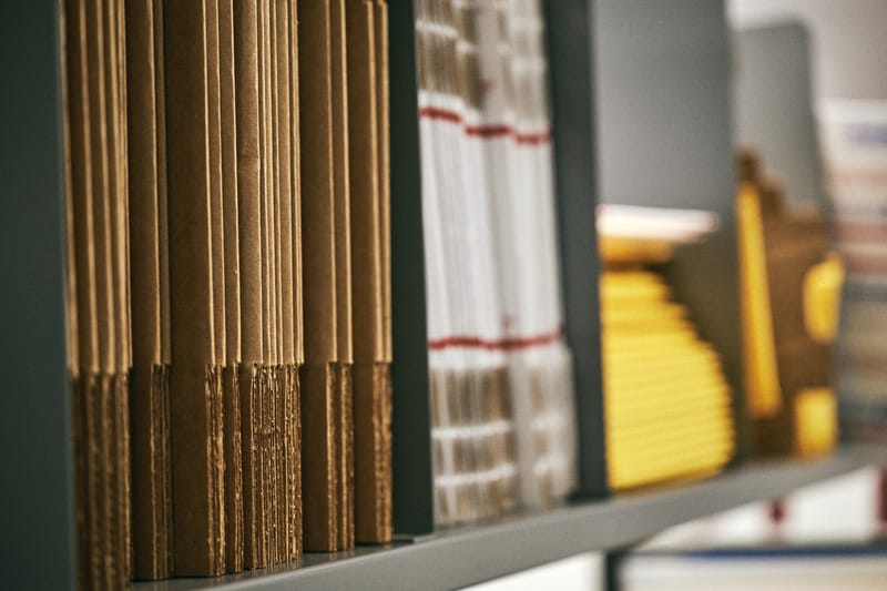 Warehouse shelving stacked with cardboard mailers and padded envelopes
